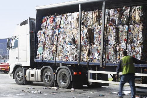 Workers using safe lifting techniques during rubbish removal
